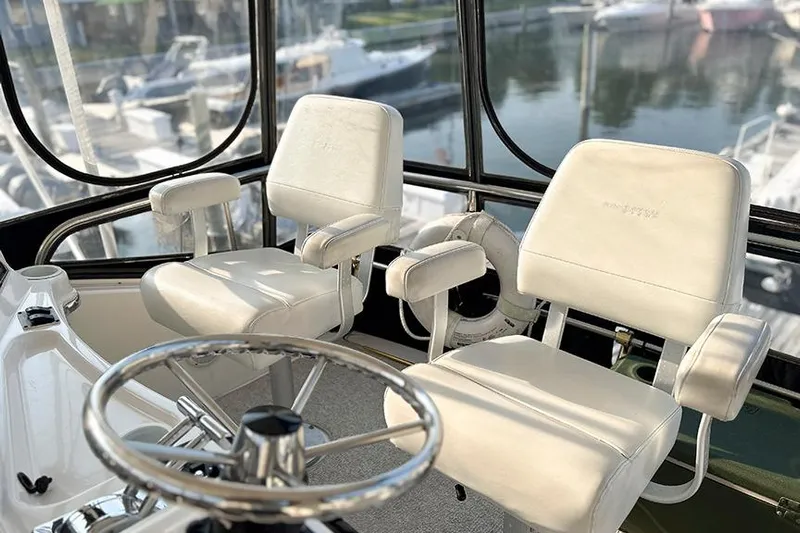  Yacht Photos Pics Interior of 2002 Silverton 42 Convertible yacht with white captain chairs and steering wheel.