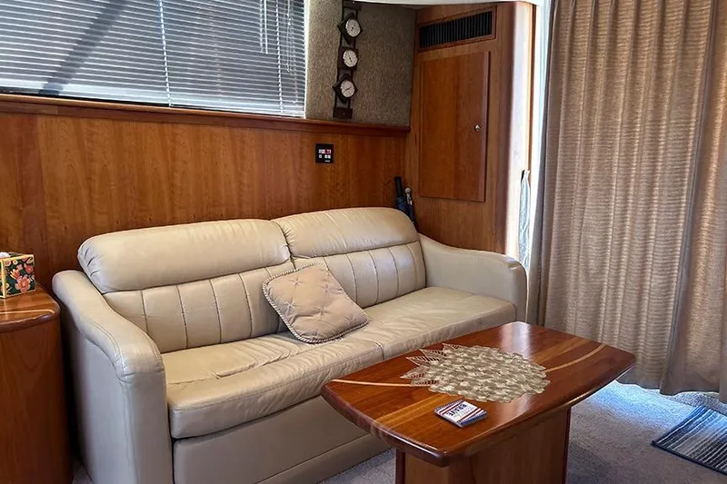  Yacht Photos Pics Interior of 2002 Silverton 42 Convertible yacht with beige sofa and wooden table.