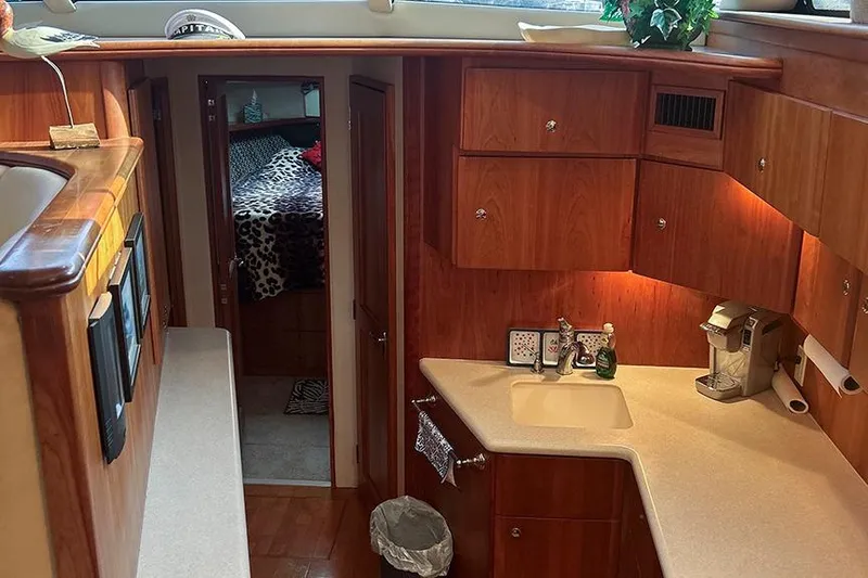  Yacht Photos Pics Interior of 2002 Silverton 42 Convertible yacht with wood cabinetry and compact kitchen area.