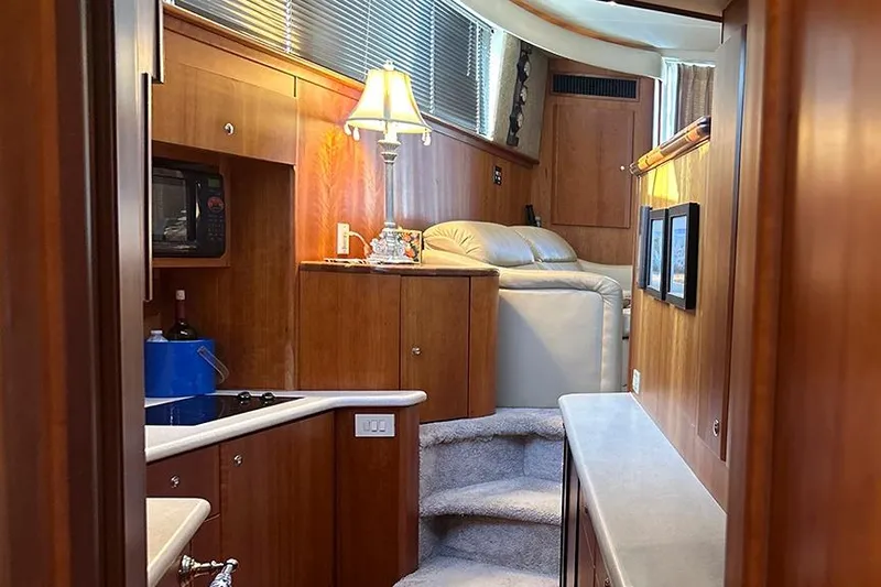  Yacht Photos Pics Interior of 2002 Silverton 42 Convertible yacht with wood paneling and cozy seating area.