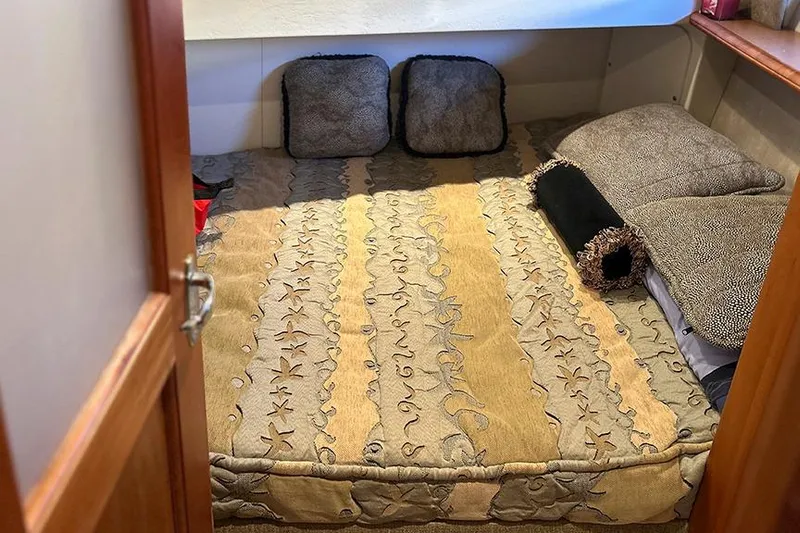  Yacht Photos Pics Cozy cabin interior of 2002 Silverton 42 Convertible with patterned bedding and cushions.