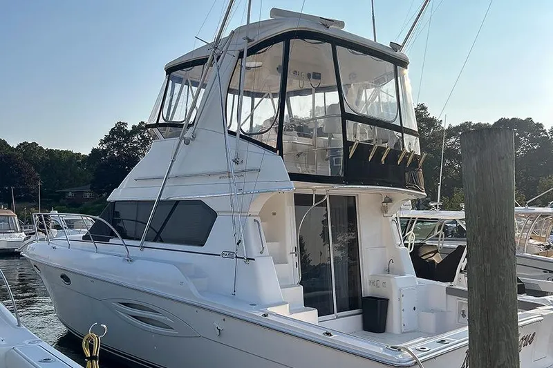  Yacht Photos Pics 2002 Silverton 42 Convertible yacht docked at a marina, featuring a spacious upper deck.