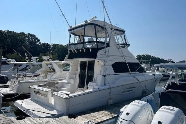  Yacht Photos Pics 2002 Silverton 42 Convertible yacht docked at marina, featuring spacious upper deck.
