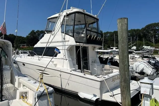  Yacht Photos Pics 2002 Silverton 42 Convertible yacht docked at marina under clear blue sky.