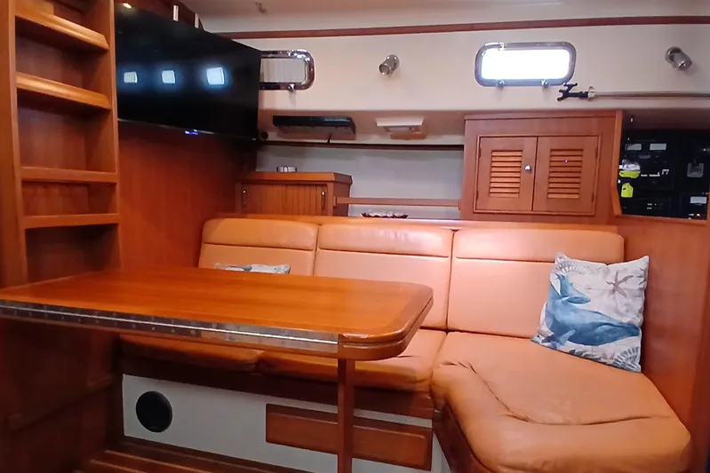 Nowhere To Be Yacht Photos Pics Interior of 2006 Island Packet 440 yacht with leather seating and wooden table.