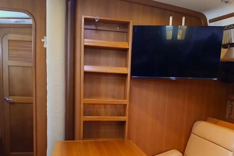 Nowhere To Be Yacht Photos Pics Interior of 2006 Island Packet 440 yacht with wooden shelves and mounted TV.