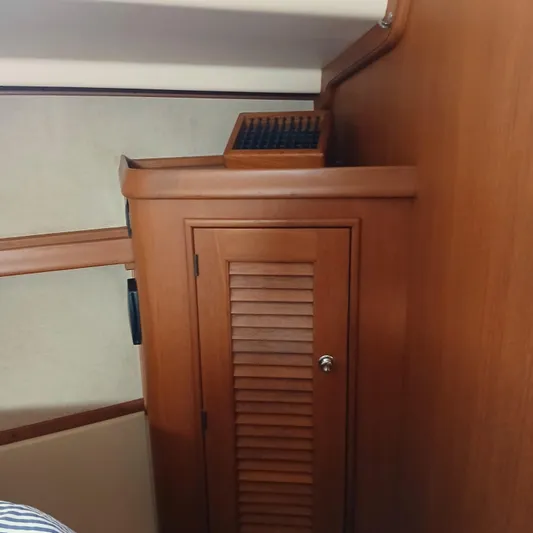 Nowhere To Be Yacht Photos Pics Wooden interior of 2006 Island Packet 440 yacht, featuring a cabinet with louvered door.