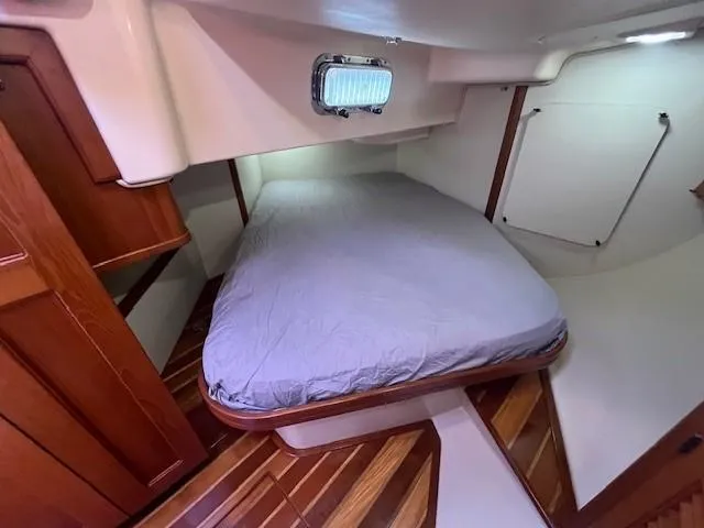 Nowhere To Be Yacht Photos Pics Cozy cabin interior of 2006 Island Packet 440 sailboat with wooden flooring and bed.