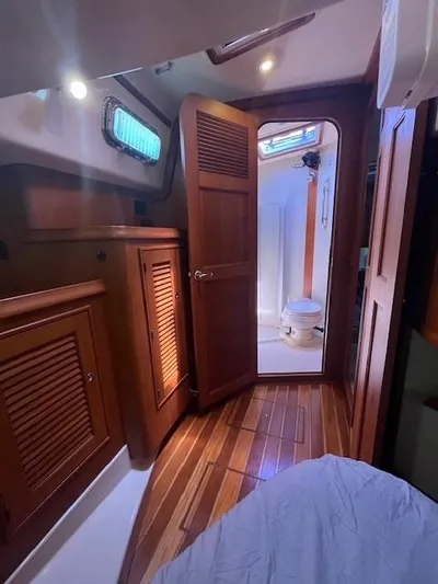 Nowhere To Be Yacht Photos Pics Interior of 2006 Island Packet 440 sailboat with wooden cabinetry and visible bathroom.