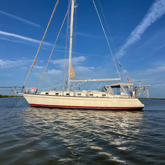 Nowhere To Be Yacht Photos Pics 2006 Island Packet 440 sailboat on calm water under a clear blue sky.