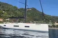 2023 Solaris 50 yacht sailing near a lush, green coastline.