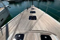 2023 Solaris 50 yacht deck in marina, surrounded by boats and mountains.