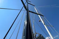 Tall mast of a 2023 Solaris 50 sailboat against a clear blue sky.