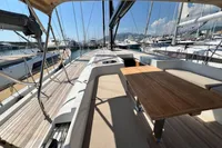 2023 Solaris 50 yacht deck with wooden table, docked in a marina under clear skies.