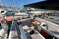 Luxurious 2023 Solaris 50 yacht docked at marina, featuring spacious deck and seating area.