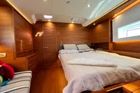 Luxurious interior cabin of 2023 Solaris 50 yacht with wooden finish and cozy bed.