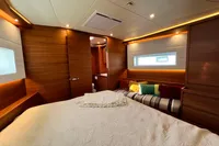 Luxurious interior of 2023 Solaris 50 yacht with cozy bed and modern wood paneling.