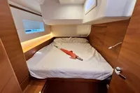 Luxurious cabin interior of 2023 Solaris 50 yacht with cozy bed and wooden finish.