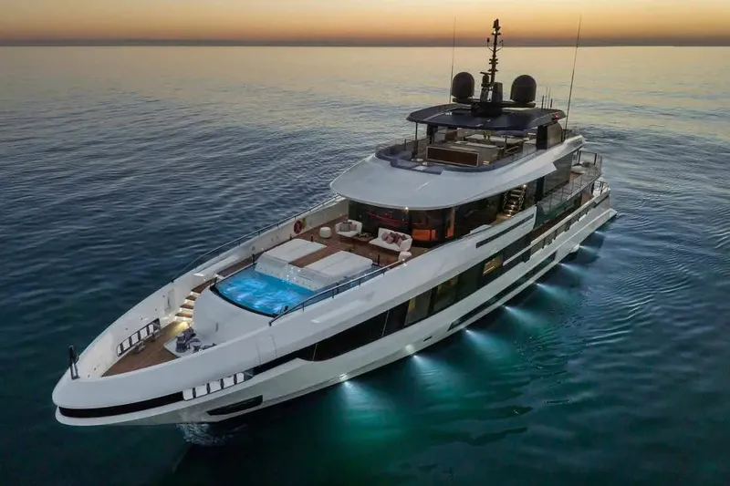 Oceano 44 Yacht Photos Pics Luxurious 2027 Mangusta Oceano 44 yacht at sunset, featuring elegant design and illuminated deck.