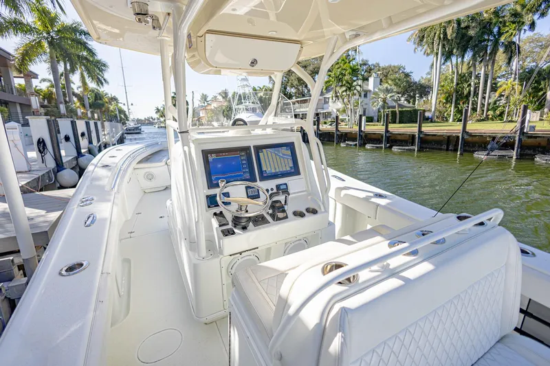 Done Deal Yacht Photos Pics 2015 Yellowfin 32 Offshore boat with modern dashboard, docked near palm trees.