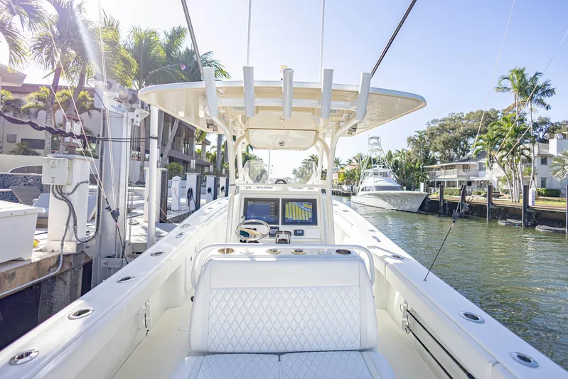 Done Deal Yacht Photos Pics 2015 Yellowfin 32 Offshore boat docked in a sunny marina with palm trees.