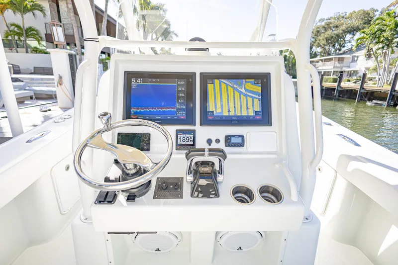 Done Deal Yacht Photos Pics 2015 Yellowfin 32 Offshore boat dashboard with navigation screens and steering wheel.
