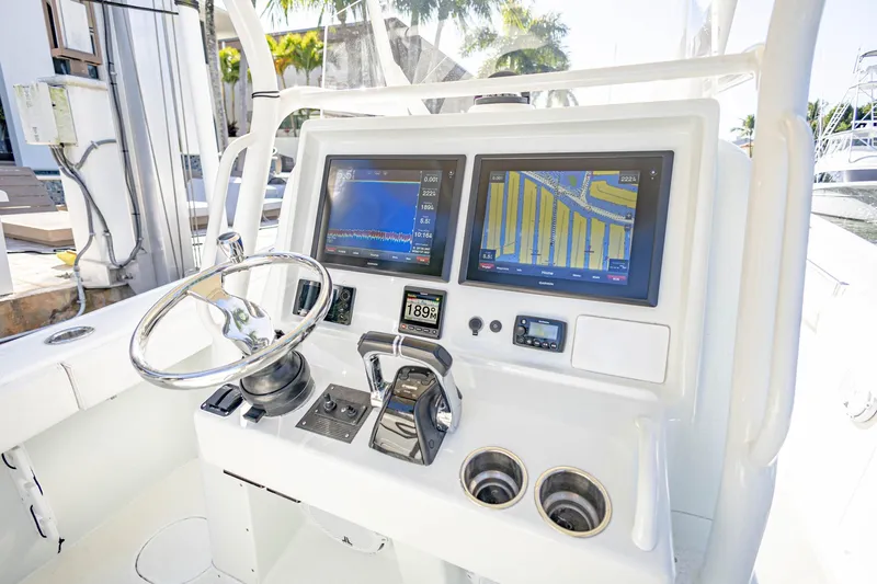 Done Deal Yacht Photos Pics 2015 Yellowfin 32 Offshore boat dashboard with dual navigation screens and steering wheel.