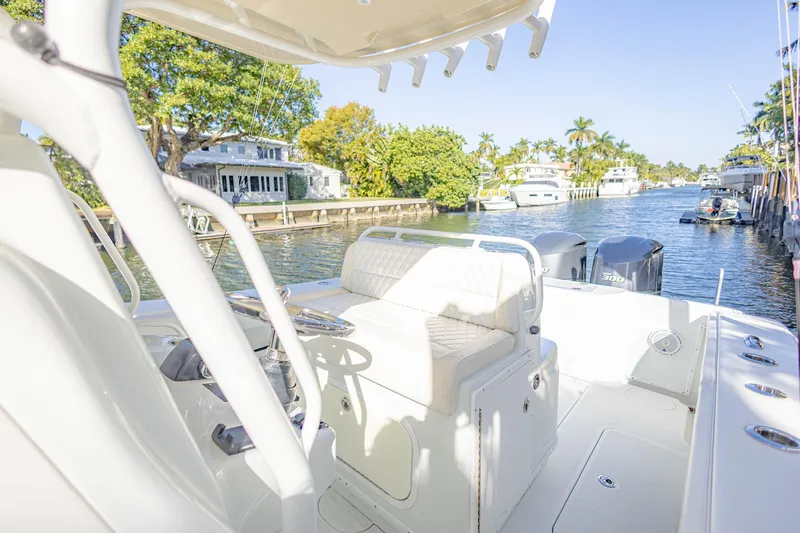Done Deal Yacht Photos Pics 2015 Yellowfin 32 Offshore boat on a sunny canal with lush greenery.