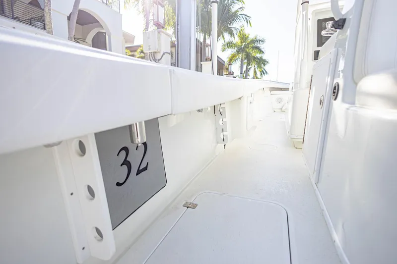 Done Deal Yacht Photos Pics 2015 Yellowfin 32 Offshore boat interior with sleek white design and palm trees in background.