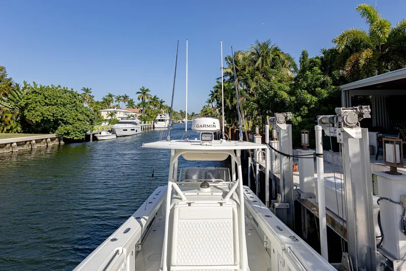 Done Deal Yacht Photos Pics 2015 Yellowfin 32 Offshore boat docked in a scenic canal with palm trees.