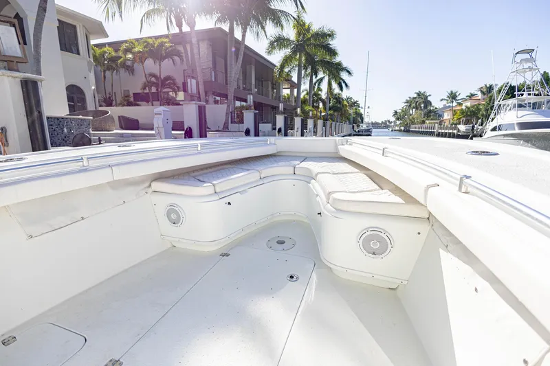 Done Deal Yacht Photos Pics 2015 Yellowfin 32 Offshore boat interior with white seating, docked near palm trees.