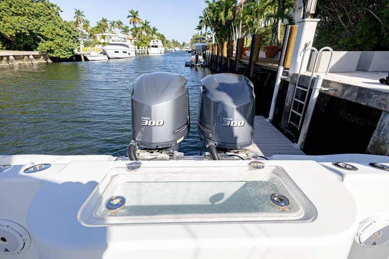Done Deal Yacht Photos Pics 2015 Yellowfin 32 Offshore boat with twin Yamaha 300 engines docked in a scenic canal.