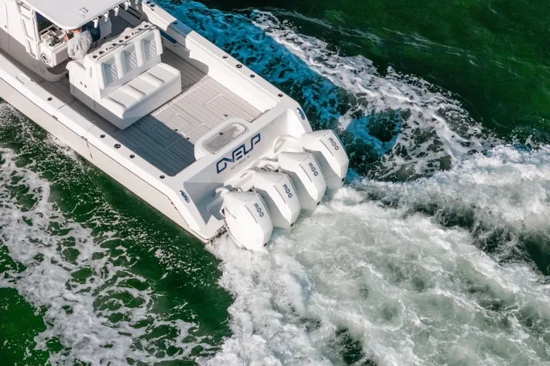  Yacht Photos Pics 2016 Invincible 42 Open Fisherman boat with triple outboard engines on green water.