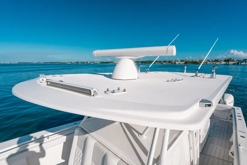  Yacht Photos Pics 2016 Invincible 42 Open Fisherman boat on calm blue waters, featuring radar equipment.