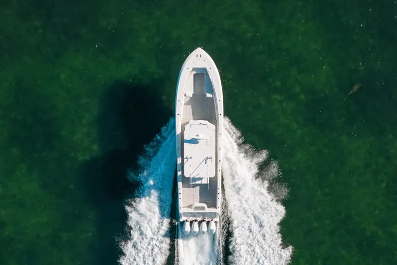  Yacht Photos Pics Aerial view of 2016 Invincible 42 Open Fisherman boat cruising on green water.