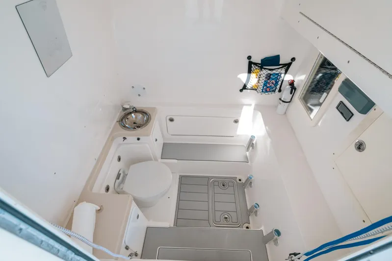  Yacht Photos Pics Interior of 2016 Invincible 42 Open Fisherman boat, featuring a compact bathroom with sink and toilet.