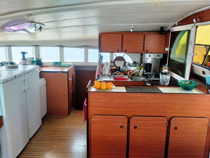  Yacht Photos Pics Interior of 2004 Lagoon 570 yacht kitchen with wooden cabinets and modern appliances.
