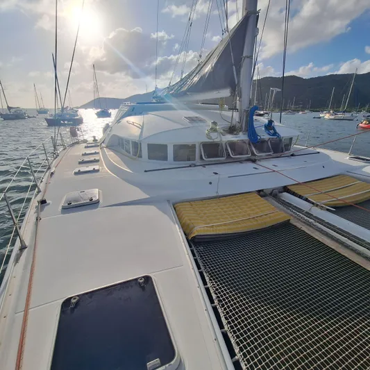  Yacht Photos Pics 2004 Lagoon 570 catamaran on water with sails, sunny sky, and distant boats.