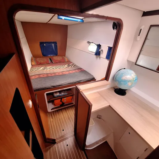  Yacht Photos Pics Interior of 2004 Lagoon 570 yacht cabin with bed, desk, and globe.