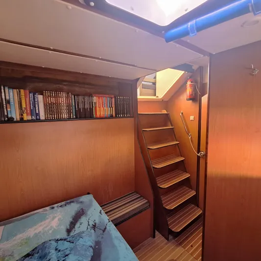  Yacht Photos Pics Interior of 2004 Lagoon 570 yacht with wooden stairs and bookshelf.