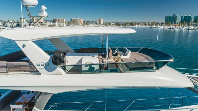 Seaduction Yacht Photos Pics Luxury 2018 Prestige 630 yacht cruising in a marina with clear blue waters.