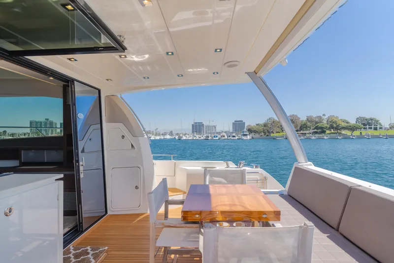Seaduction Yacht Photos Pics Luxurious 2018 Prestige 630 yacht deck with seating, table, and scenic waterfront view.