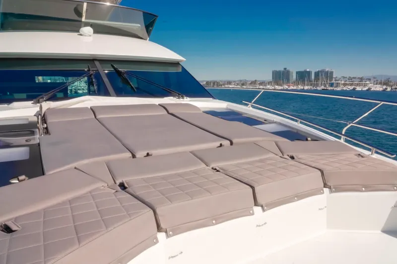 Seaduction Yacht Photos Pics Luxurious 2018 Prestige 630 yacht with sunbathing deck, city skyline in background.