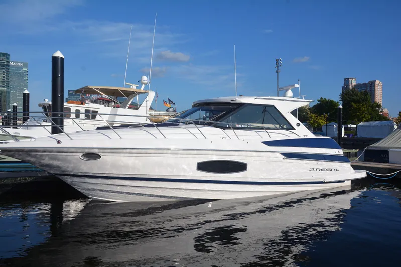  Yacht Photos Pics 2018 Regal 46 Sport Coupe yacht docked in a marina under clear blue skies.