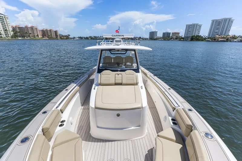  Yacht Photos Pics 2020 Pursuit S 368 Sport boat on calm water with city skyline.