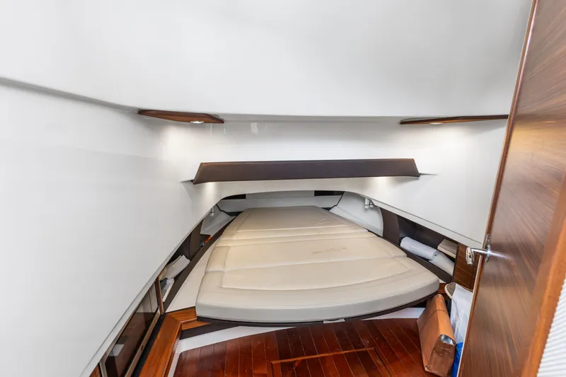  Yacht Photos Pics 2020 Pursuit S 368 Sport cabin interior with wooden flooring and cushioned bed.