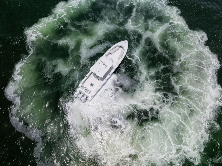  Yacht Photos Pics Aerial view of 2024 Contender 39 ST boat creating circular wake in the ocean.