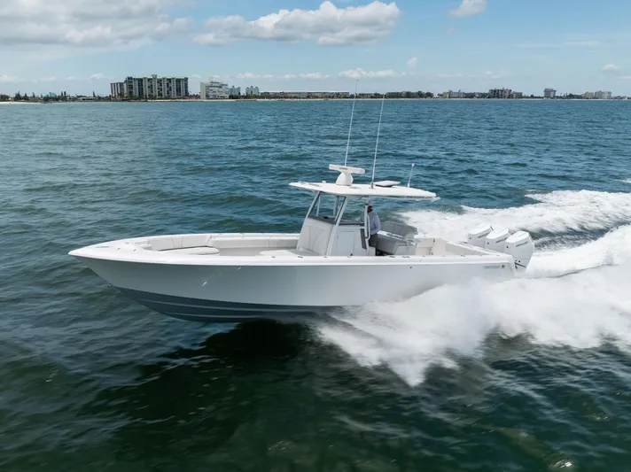  Yacht Photos Pics 2024 Contender 39 ST boat cruising on open water, cityscape in background.