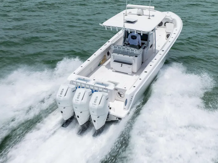  Yacht Photos Pics 2024 Contender 39 ST boat cruising on open water with triple outboard engines.