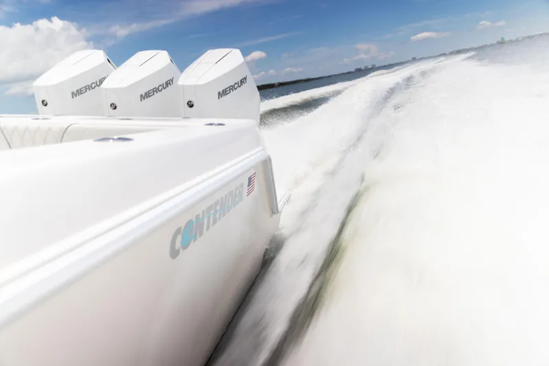  Yacht Photos Pics 2024 Contender 39 ST boat with triple Mercury engines speeding on open water.